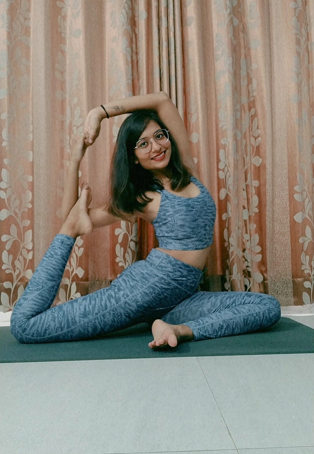 Dhruvi practising a seated side stretch indoors