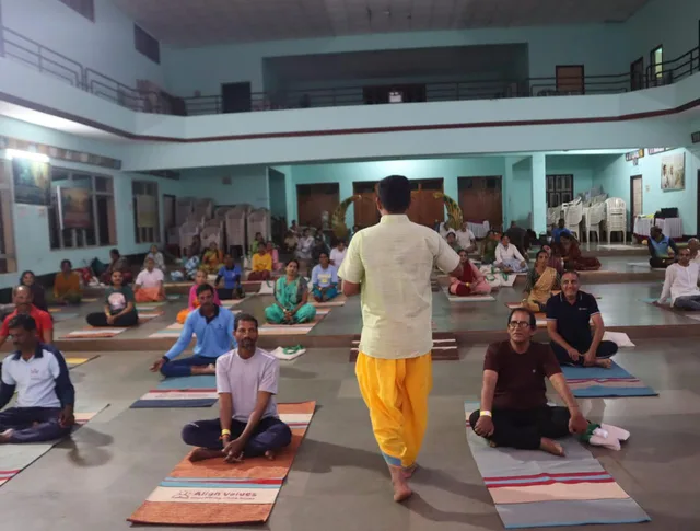Nikhil leading a seated practice in a community hall in Honnavara