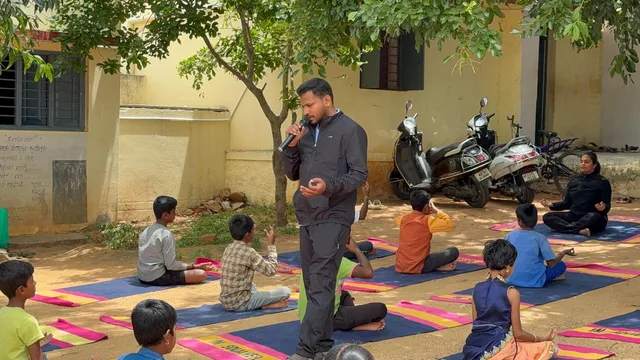Nikhil guiding children through an outdoor school yoga session