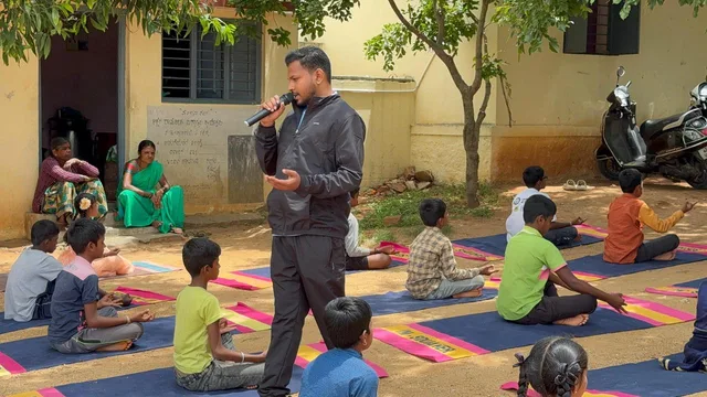 Children practising seated yoga with Nikhil at school