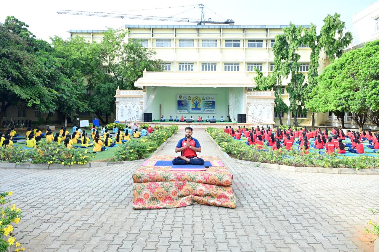 Participants practising yoga together in a campus courtyard